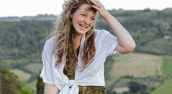 Alexa sitting outside with rolling hills and farms in background