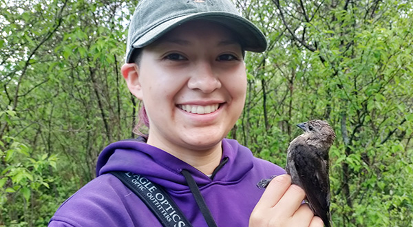 student with bird perched on hand