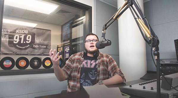 student speaks into microphone in KSDB 91.9 FM radio station studio
